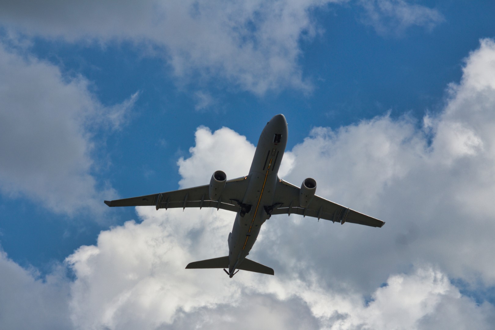 A photo of a mid air refuelling tanker flying overhead at a low altitude